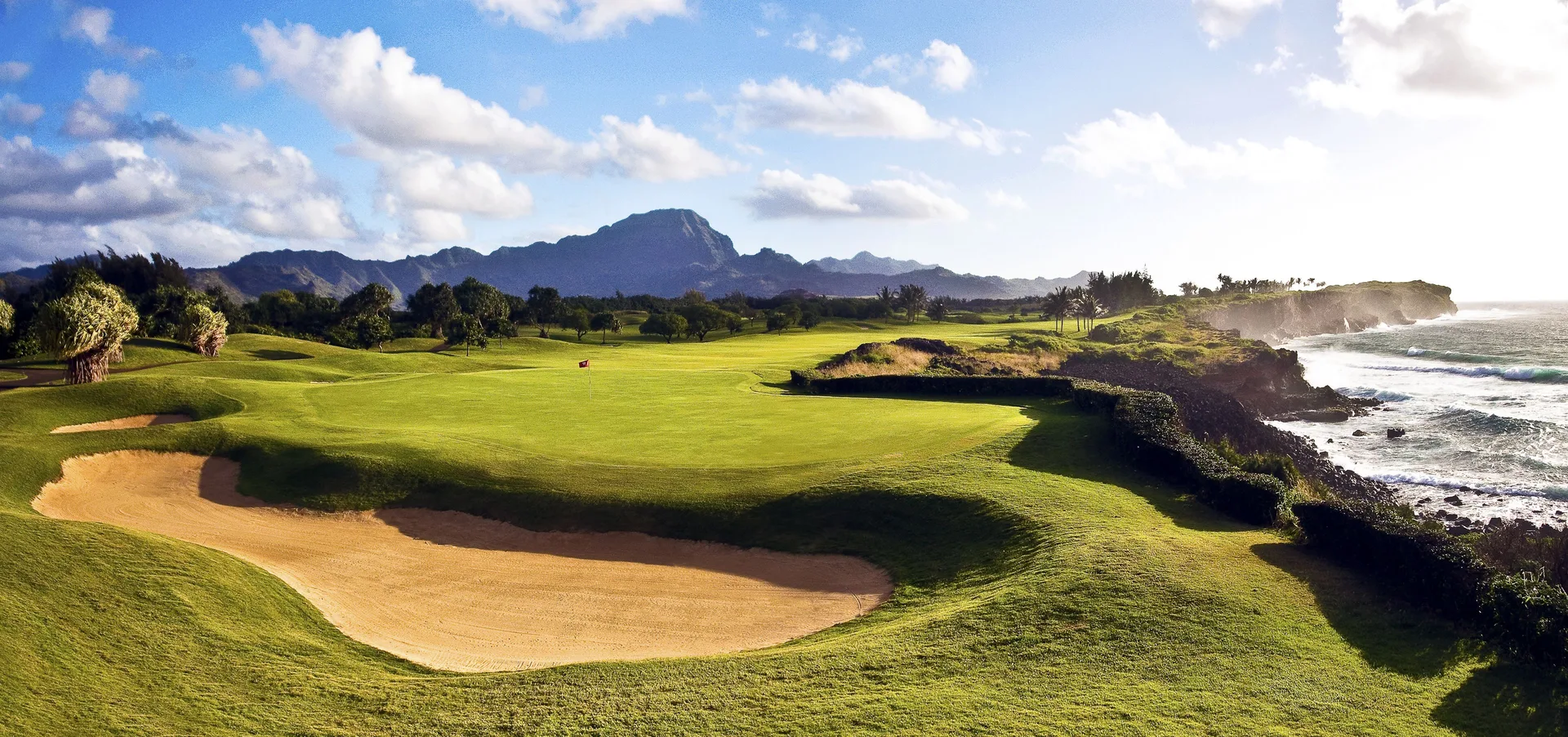 An oceanfront golf course with bunkers near Grand Hyatt Kauai Resort and Spa and Spa.