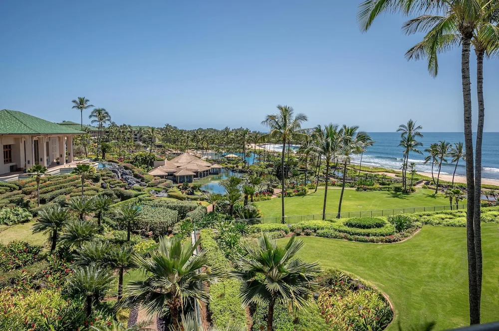 Oceanfront resort grounds with palms and beach at Grand Hyatt Kauai Resort and Spa and Spa.
