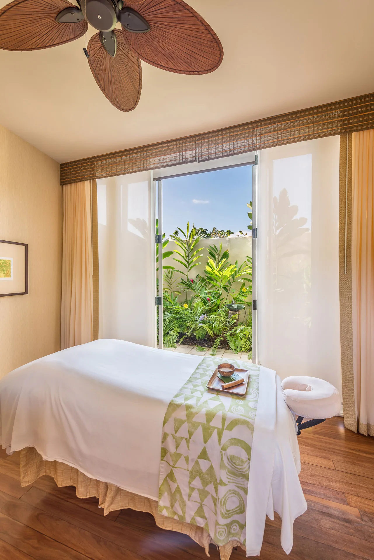 Spa room at Grand Hyatt Kauai Resort and Spa and Spa with a massage table facing an open garden doorway.