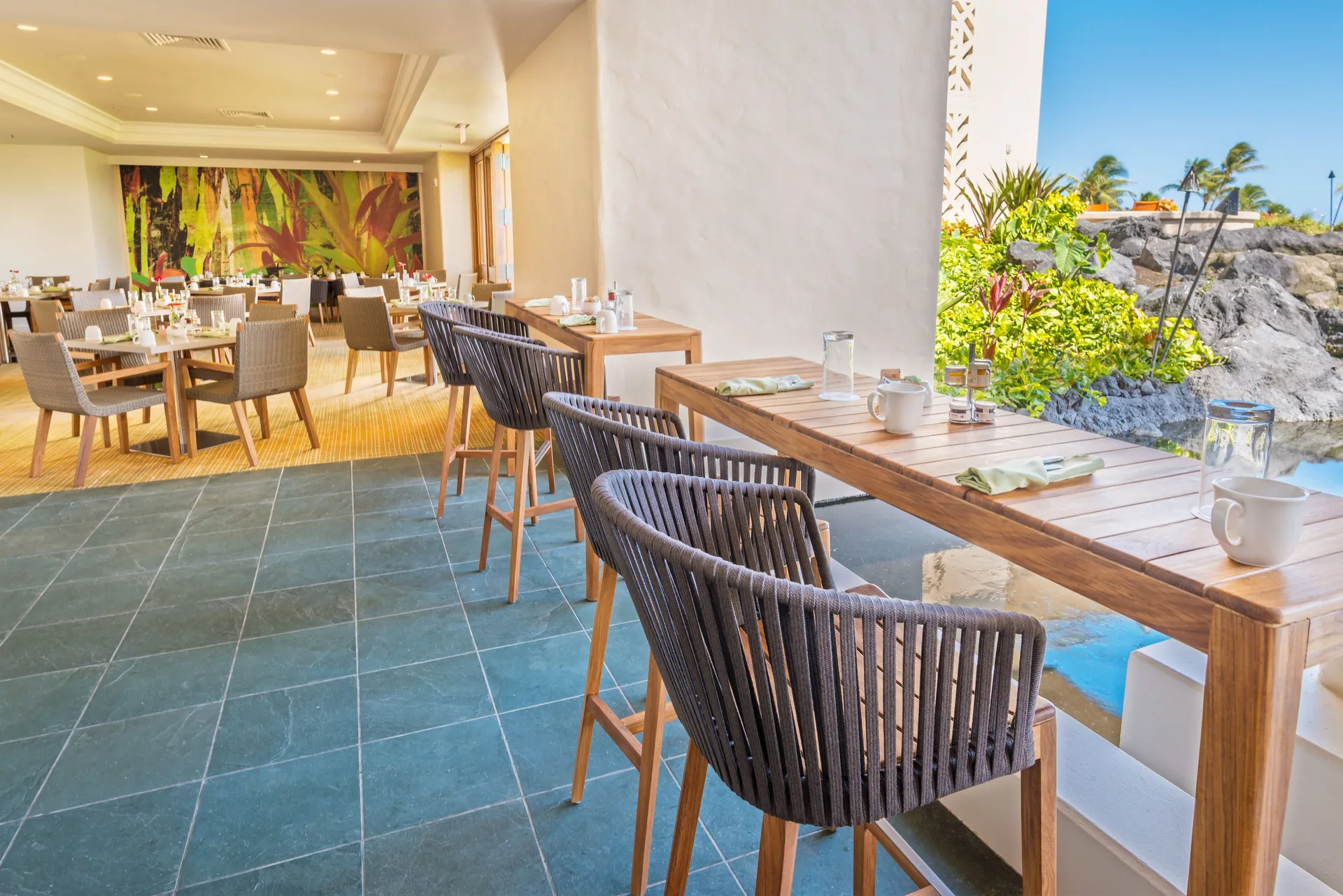 Open-air dining area with garden views at Grand Hyatt Kauai Resort and Spa and Spa.