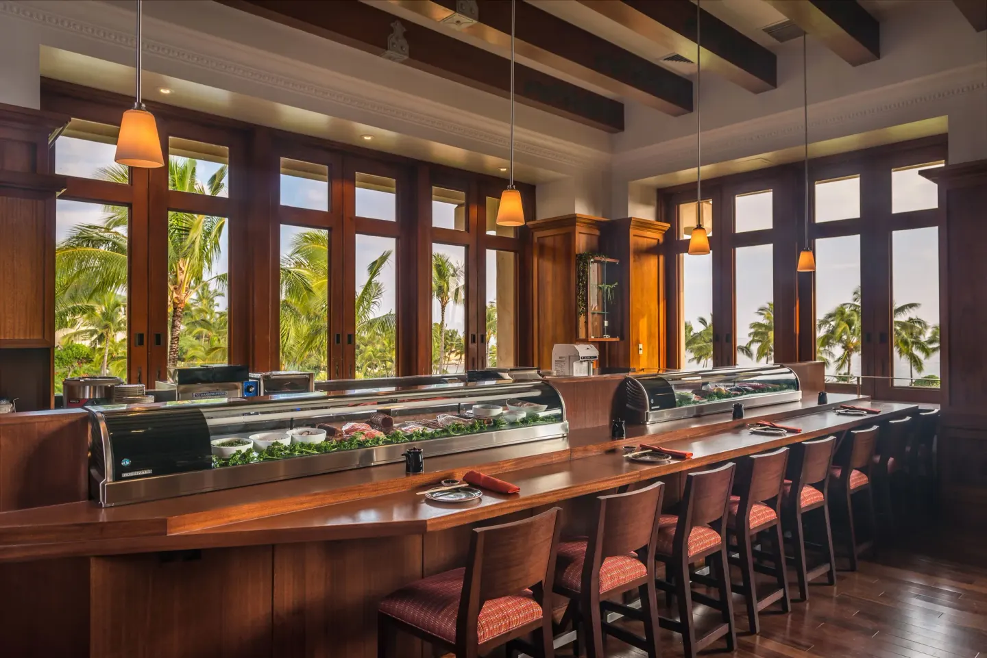Sushi counter with wood seating and palm views at Grand Hyatt Kauai Resort and Spa and Spa.