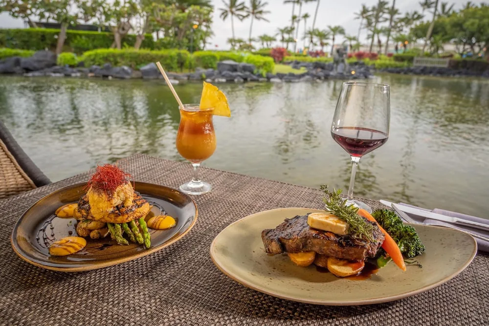 Steak, seafood dish, wine and tropical cocktail by the lagoon at Grand Hyatt Kauai Resort and Spa and Spa.