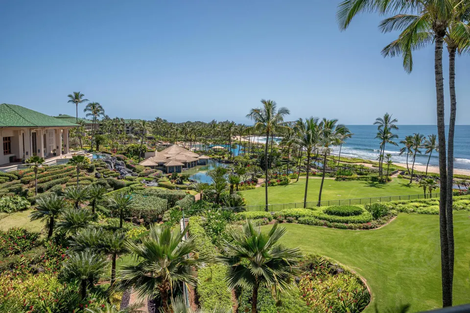 Ocean view over gardens, palms, pools, and shoreline at Grand Hyatt Kauai Resort and Spa and Spa.