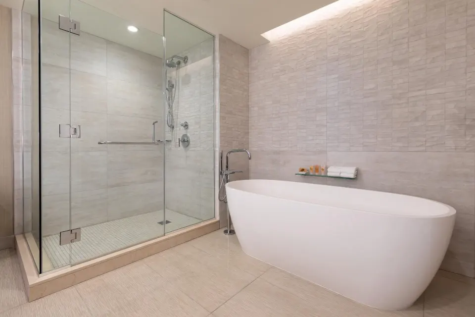 Ocean view suite bathroom with freestanding tub and glass shower at Grand Hyatt Kauai Resort and Spa and Spa.