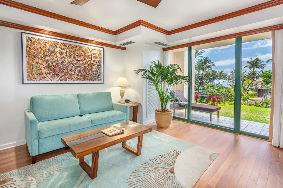Pool Suite sitting room with blue sofa and garden view at Grand Hyatt Kauai Resort and Spa and Spa.