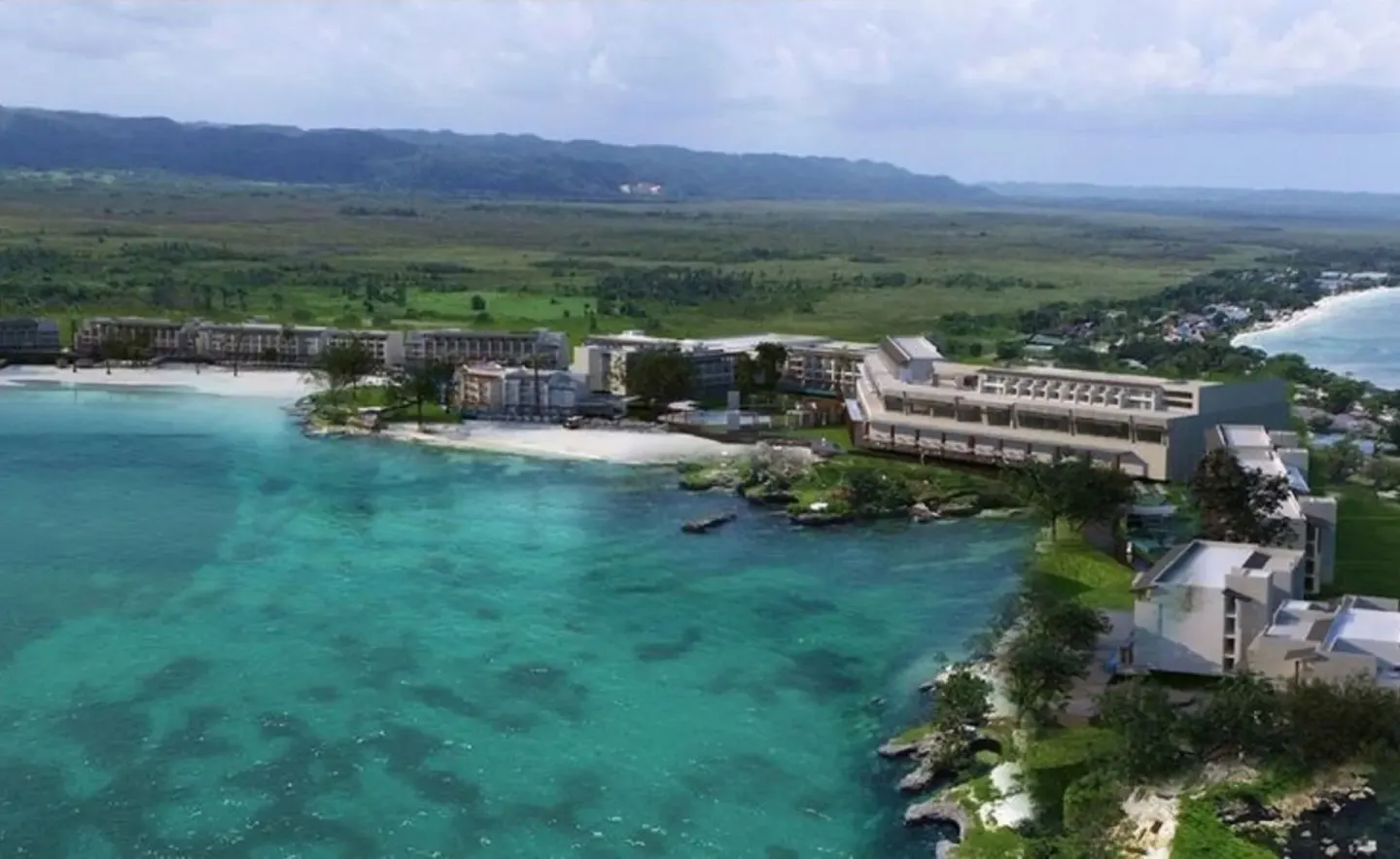 Aerial coastline view of resort buildings and turquoise water at Grand Lido Negril Au-Naturel.