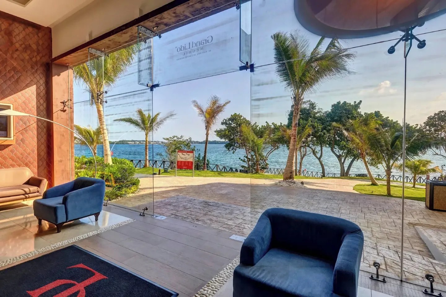 Lobby windows overlooking palms and the sea at Grand Lido Negril Au-Naturel.
