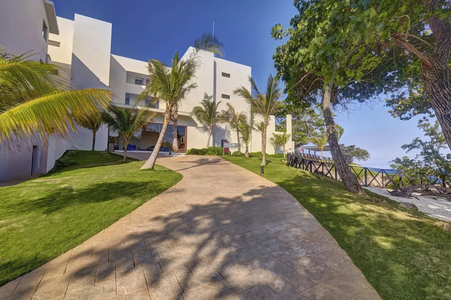 Palm-lined resort walkway and white building at Grand Lido Negril Au-Naturel.