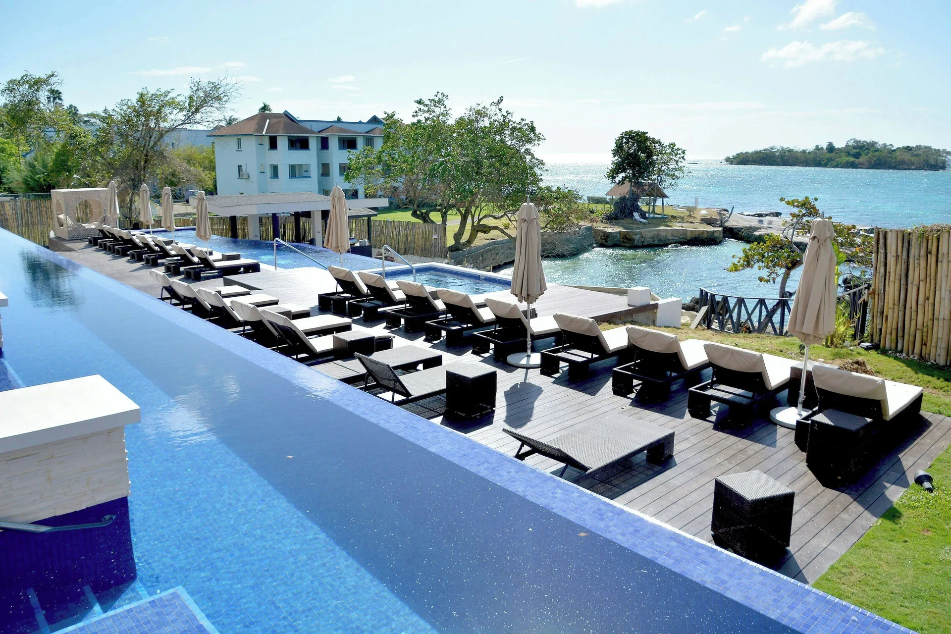 Pool deck with loungers, umbrellas, and sea views at Grand Lido Negril Au-Naturel.