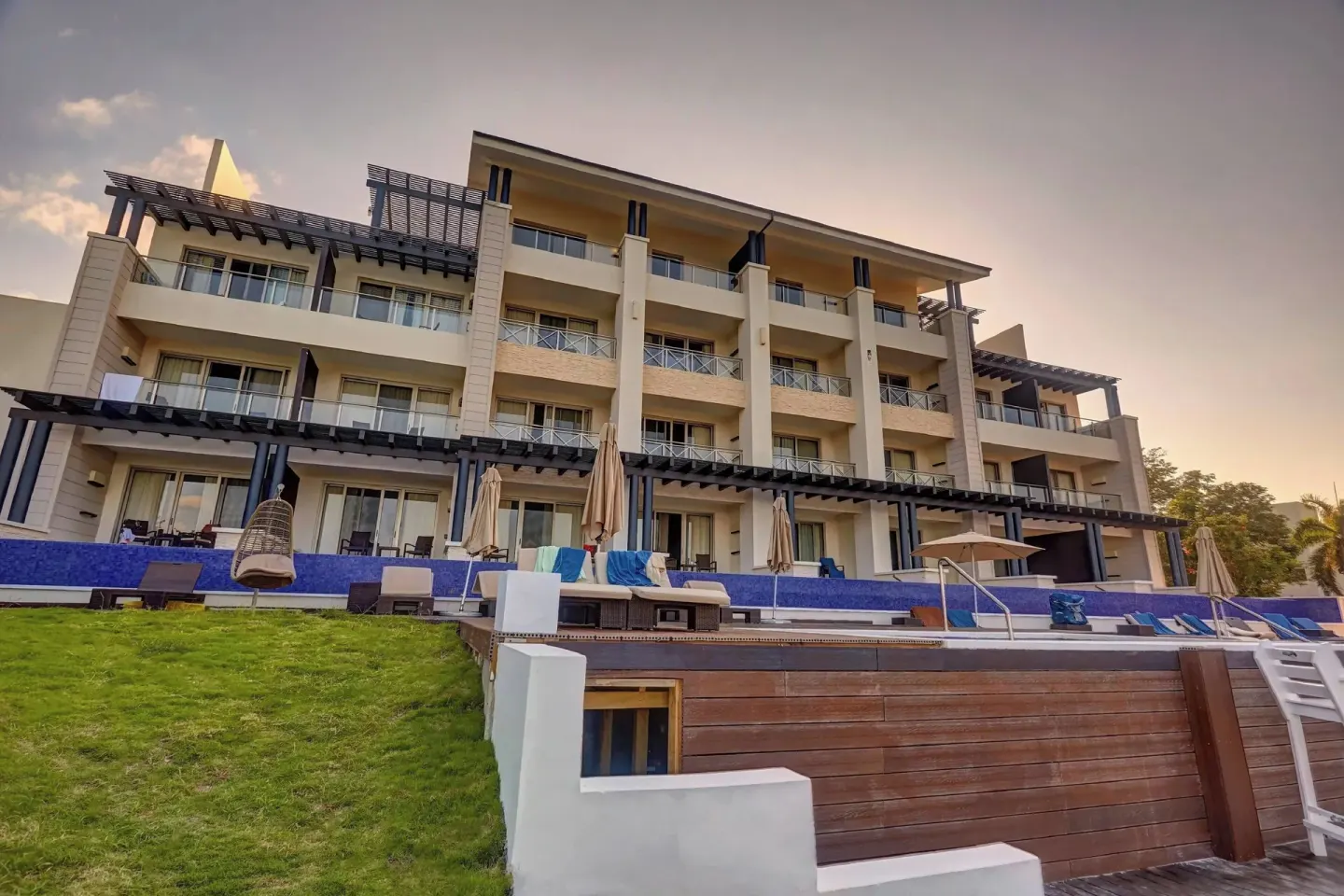Resort building with balconies, loungers, and a pool edge at Grand Lido Negril Au-Naturel.