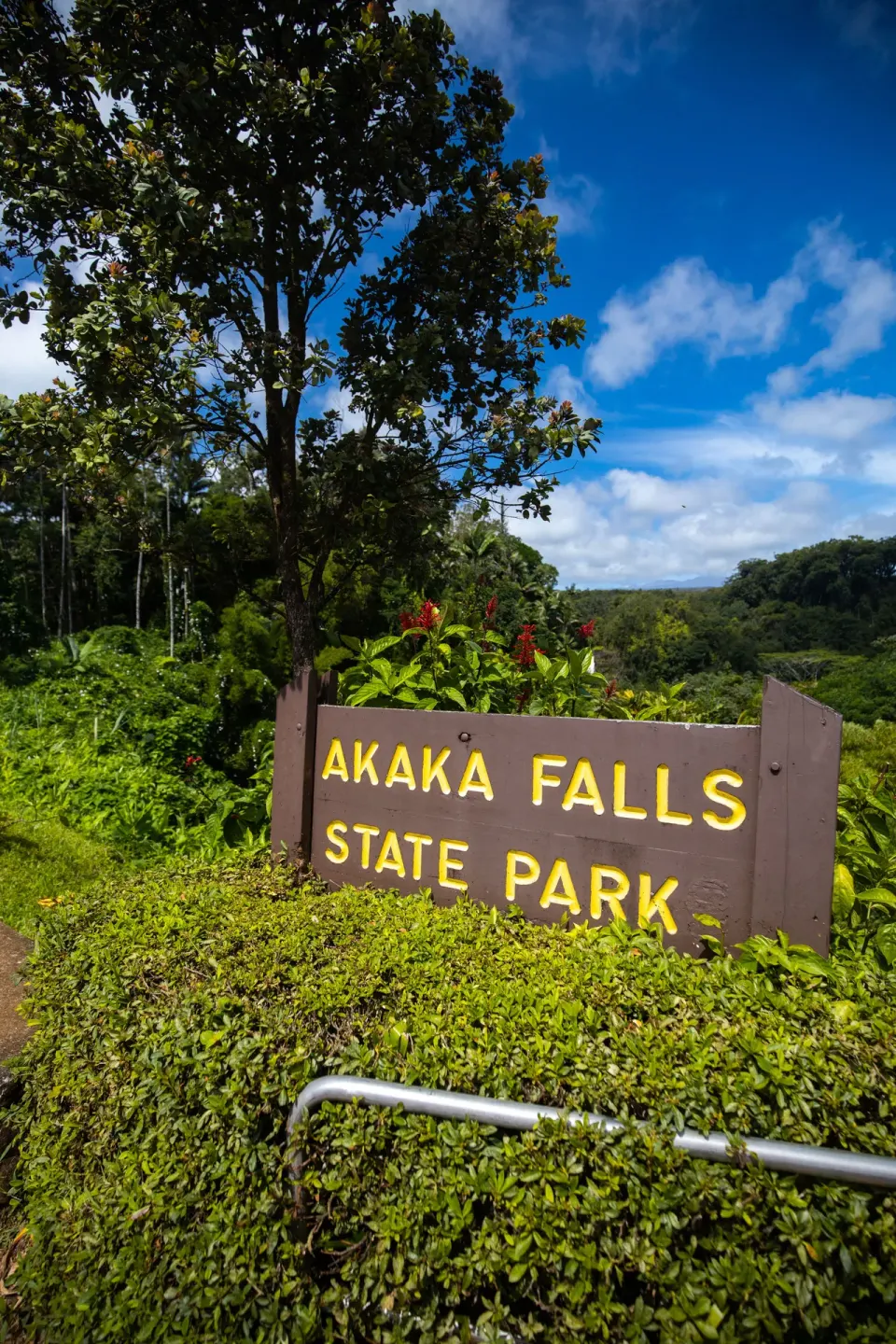 The Akaka Falls State Park sign appears amid greenery near Grand Naniloa Hotel Hilo.