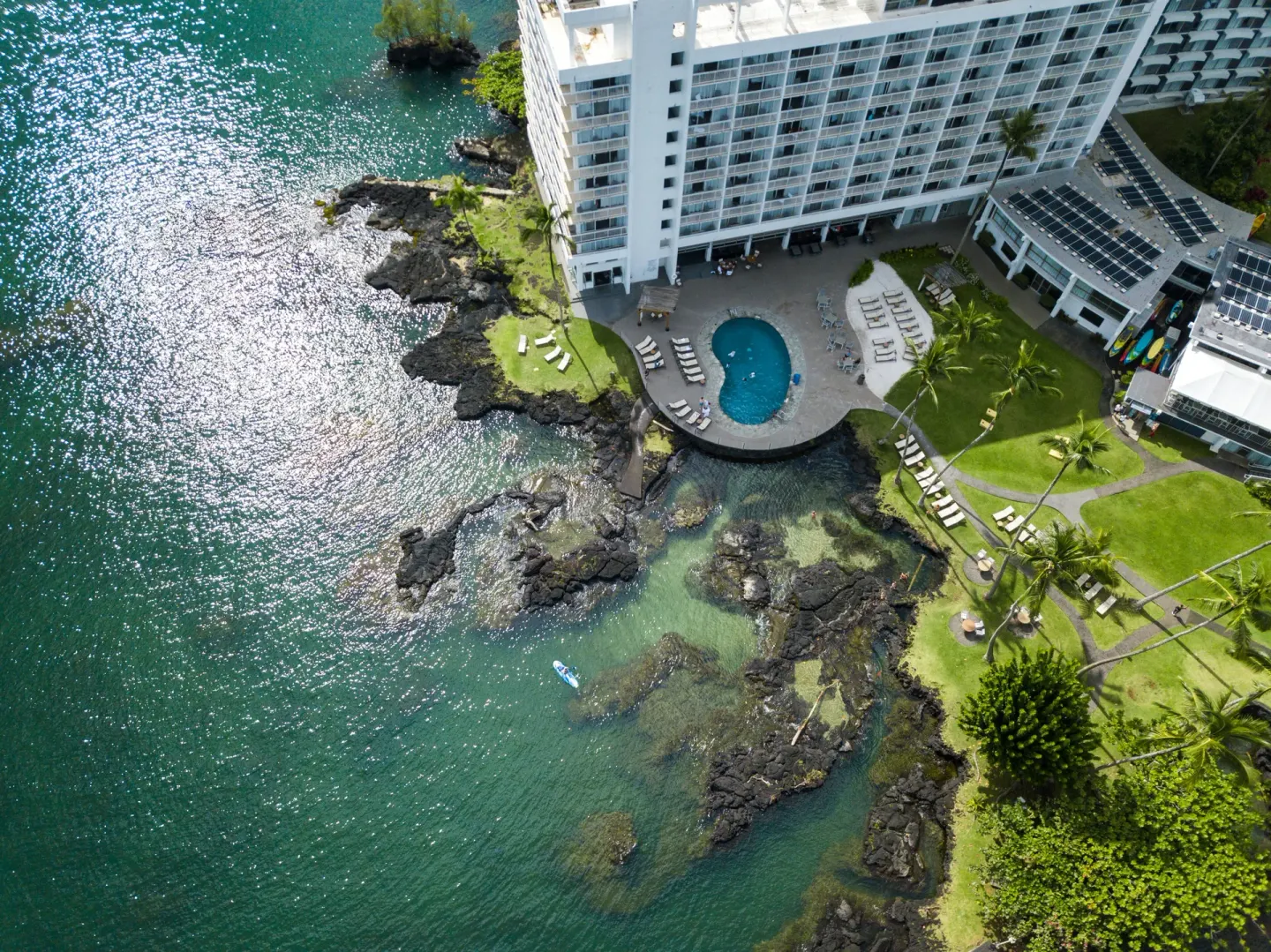 Aerial view of the oceanfront pool and lagoon at Grand Naniloa Hotel Hilo.