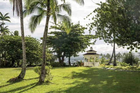 Palm lawn and white gazebo on the grounds at Grand Naniloa Hotel Hilo.