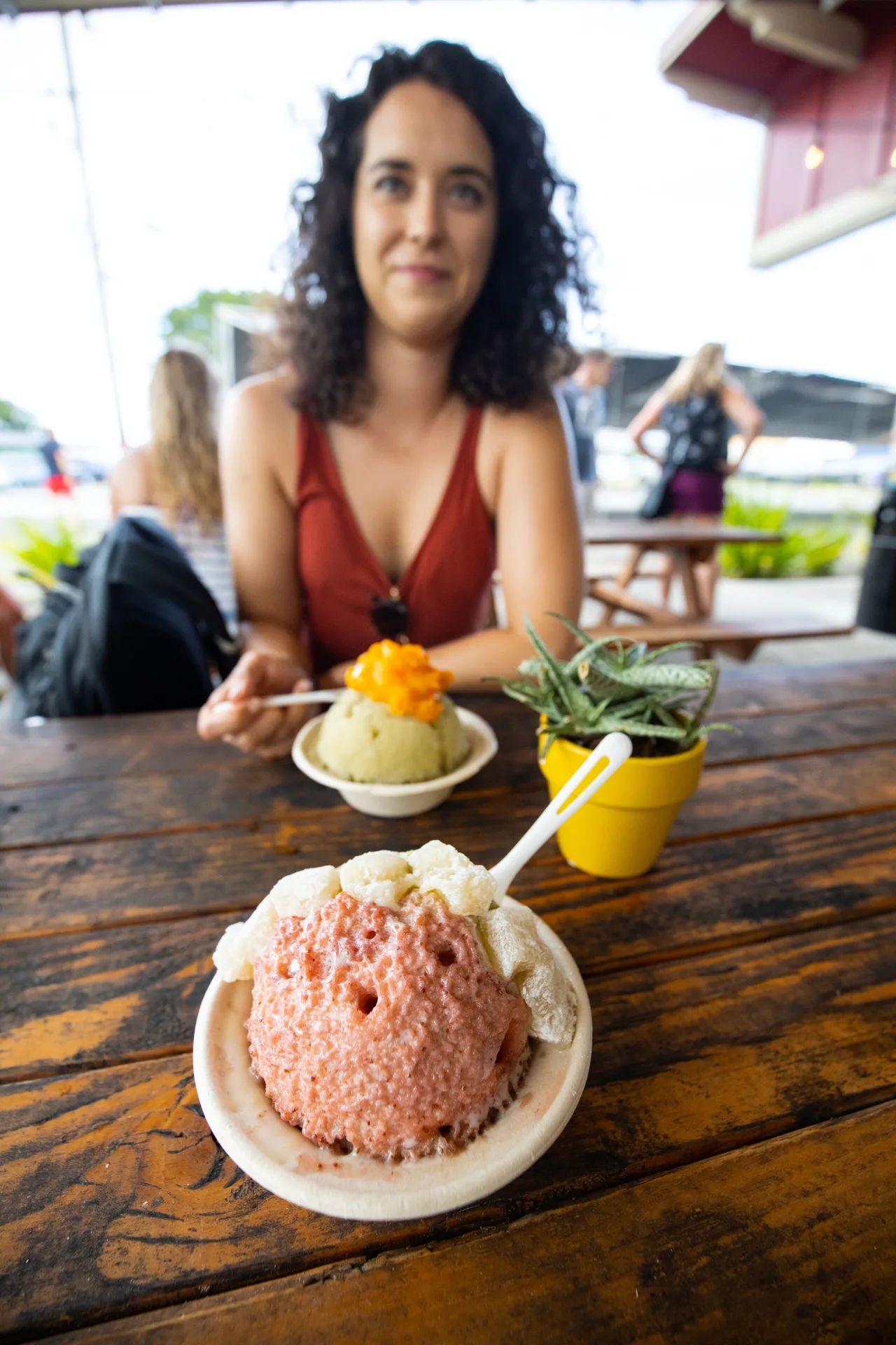Shave ice bowls on a picnic table with a guest at Grand Naniloa Hotel Hilo.