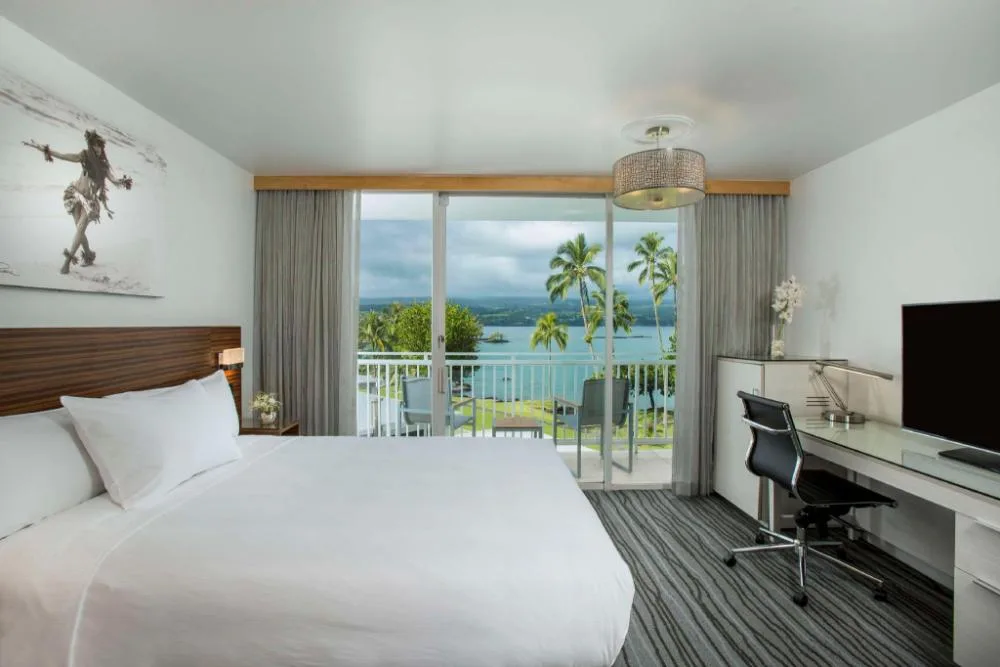 Oceanfront king guest room with lanai and desk at Grand Naniloa Hotel Hilo.