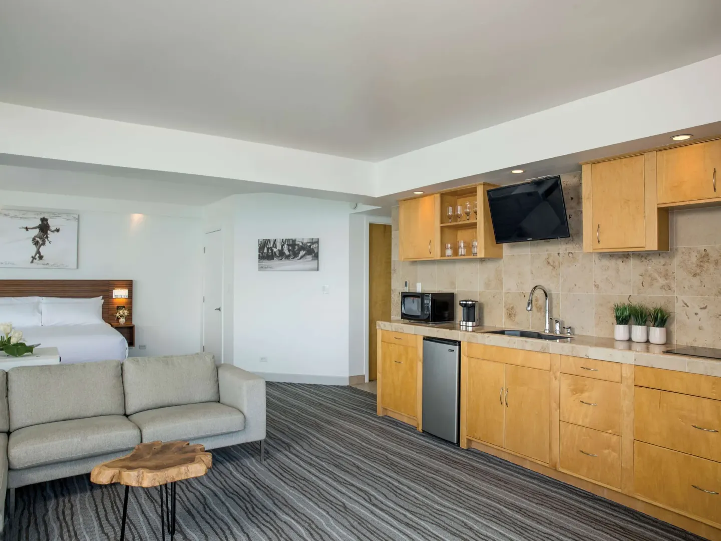 Junior suite kitchenette and living area with king bed at Grand Naniloa Hotel Hilo.