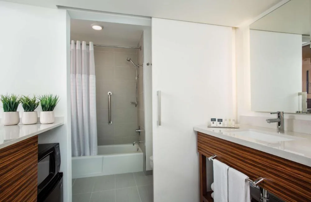 Ocean View Room bathroom with vanity and shower-tub at Grand Naniloa Hotel Hilo.