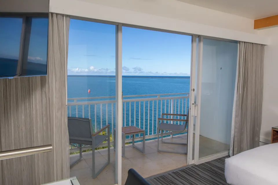 Oceanfront lanai with two chairs and blue water view at Grand Naniloa Hotel Hilo.