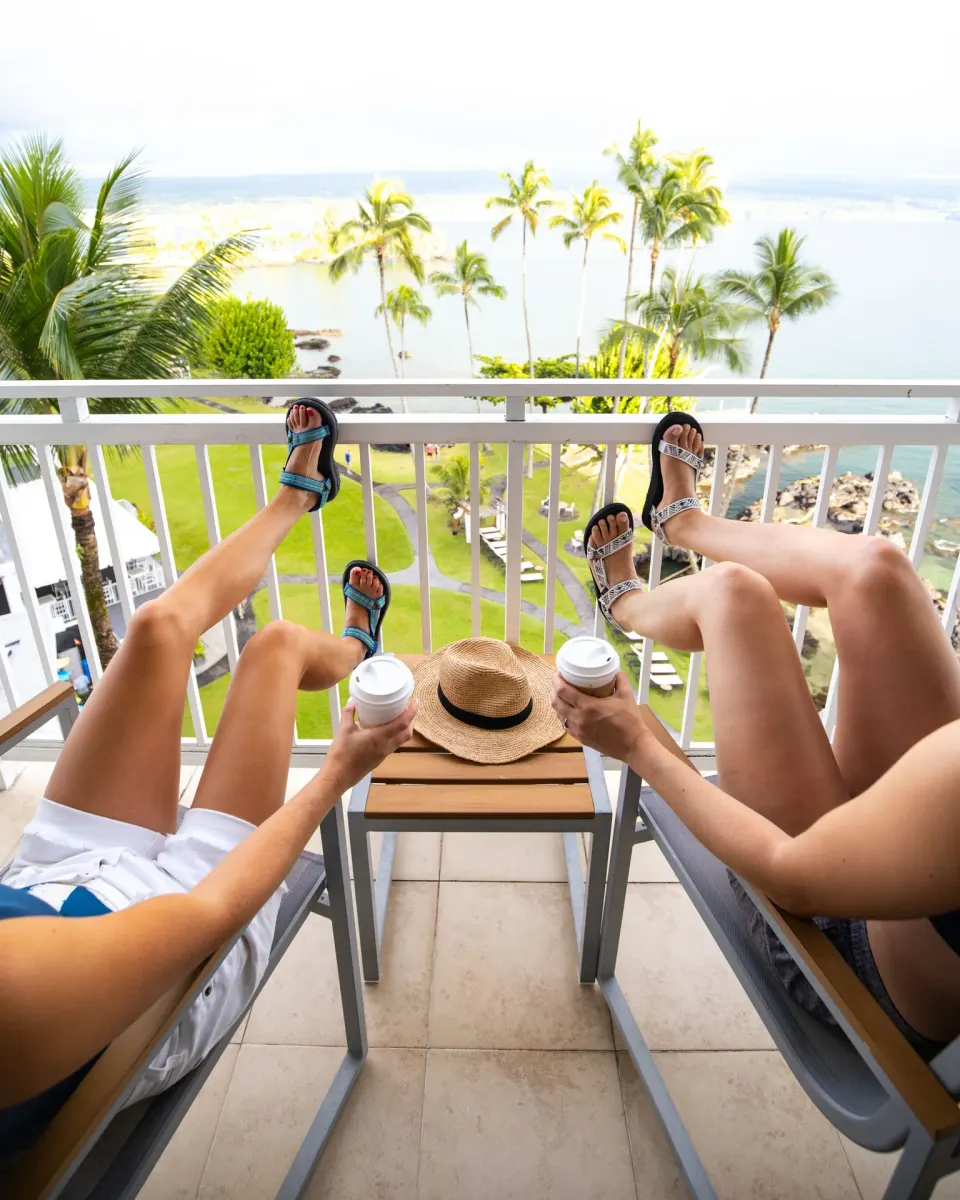 Two guests relaxing on an oceanfront lanai at Grand Naniloa Hotel Hilo.