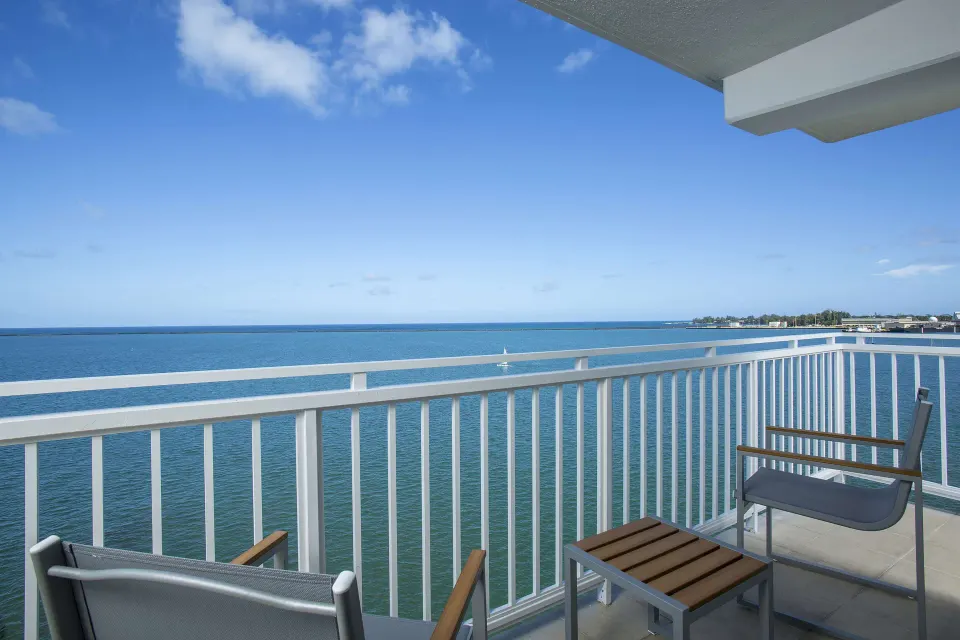Private balcony with chairs overlooking the ocean at Grand Naniloa Hotel Hilo.