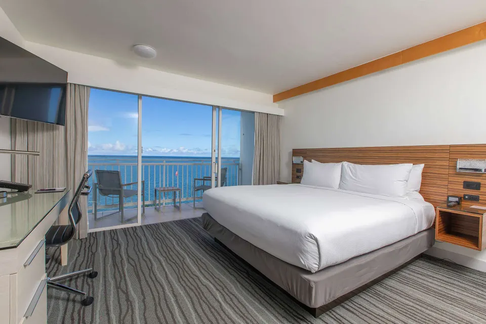 King-bed ocean view room with balcony and desk at Grand Naniloa Hotel Hilo.