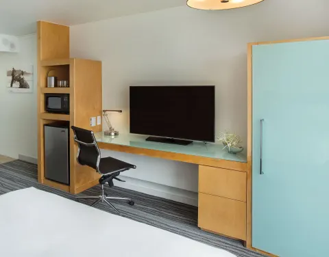 Room work area with TV, desk, microwave and mini-fridge at Grand Naniloa Hotel Hilo.