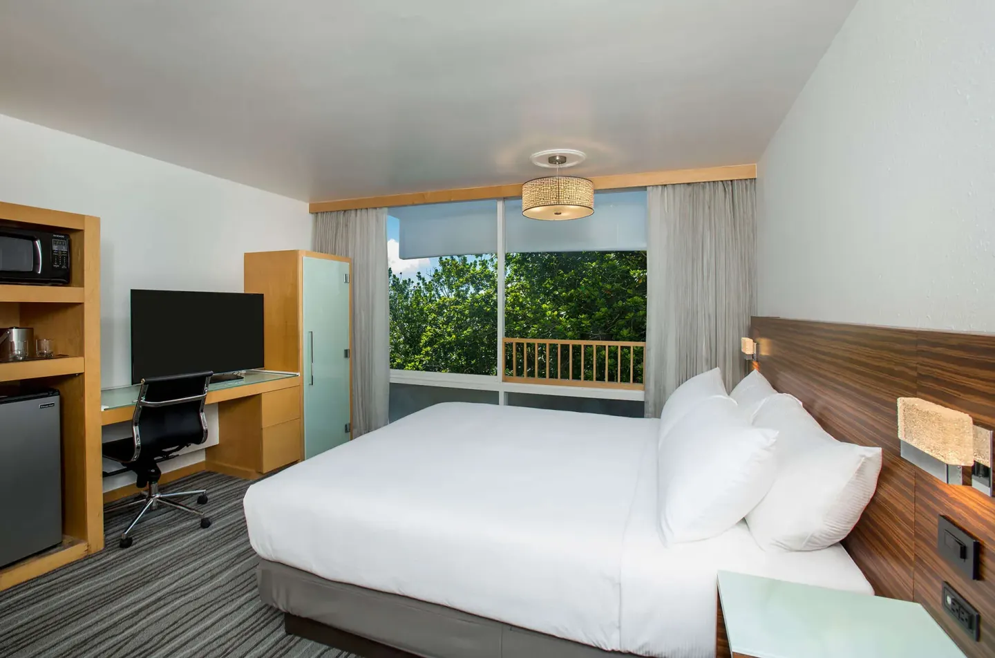 Non-smoking king room with balcony window and desk at Grand Naniloa Hotel Hilo.