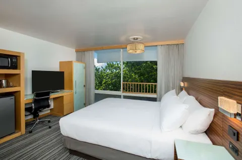 Non-smoking king room with balcony window and desk at Grand Naniloa Hotel Hilo.