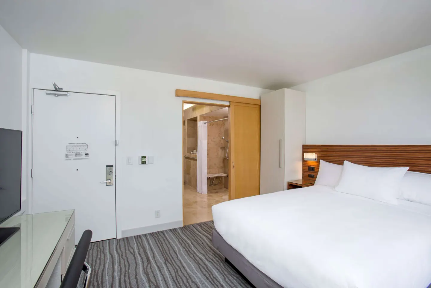 Non-smoking king room with open bathroom doorway at Grand Naniloa Hotel Hilo.