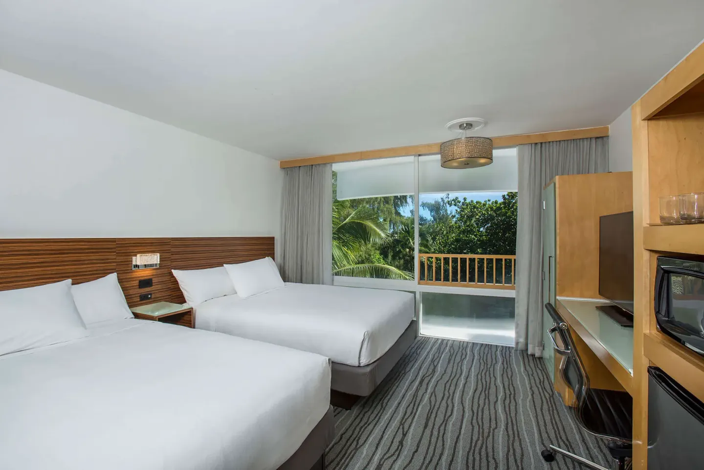 Non-smoking room with two beds and balcony doors at Grand Naniloa Hotel Hilo.