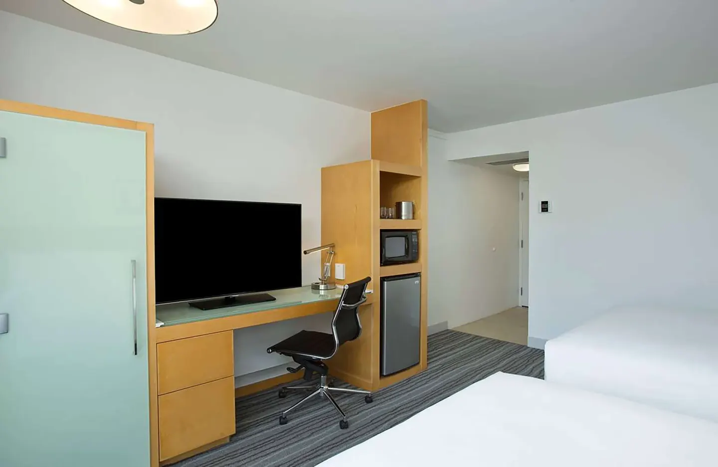 Non-smoking guest room work area with TV and storage at Grand Naniloa Hotel Hilo.