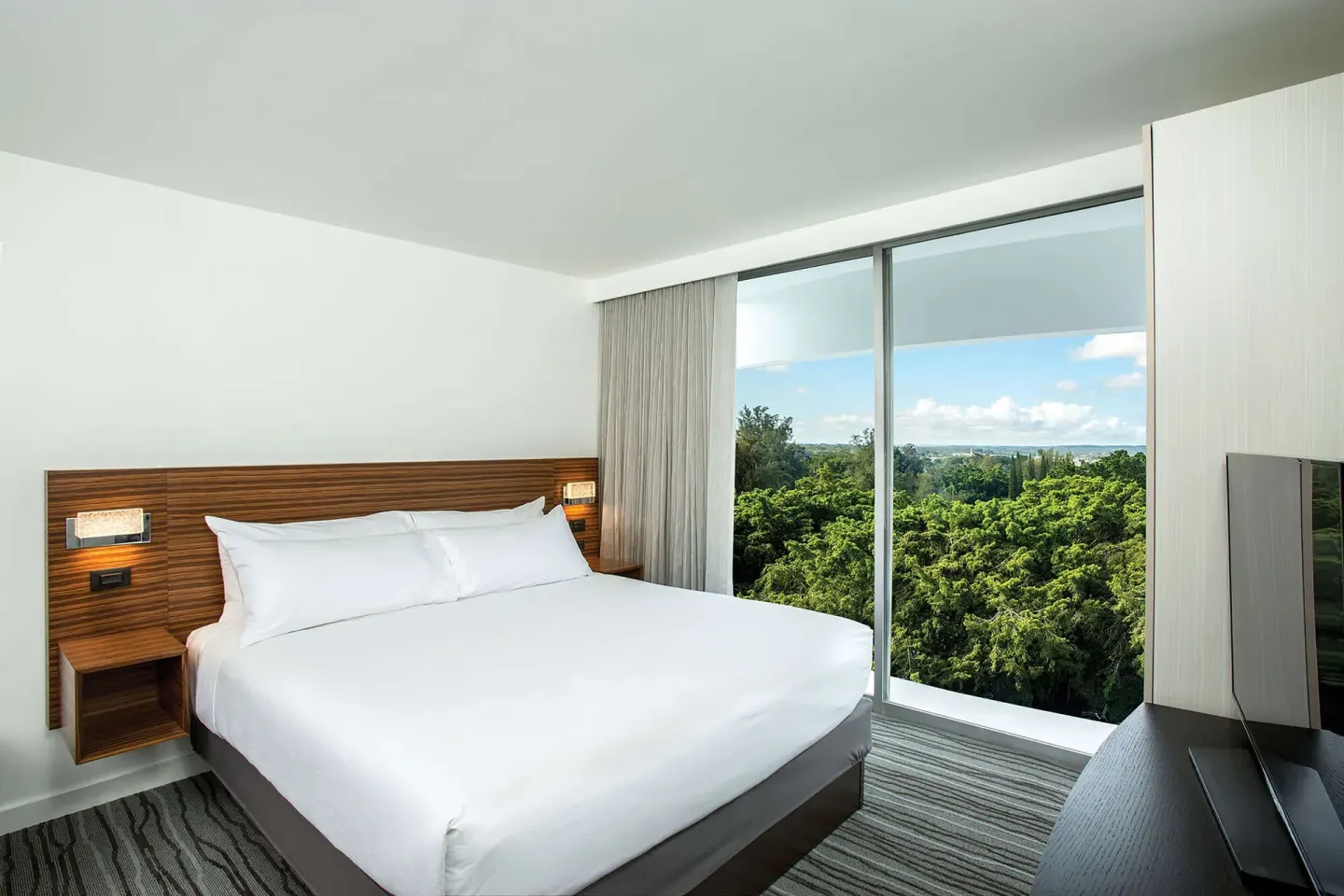 King bedroom with floor-to-ceiling windows at Grand Naniloa Hotel Hilo.