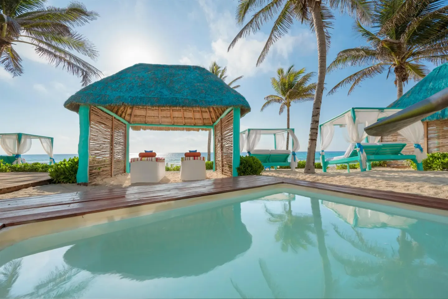 Beachside cabana and plunge pool under palms at Grand Oasis Cancun.