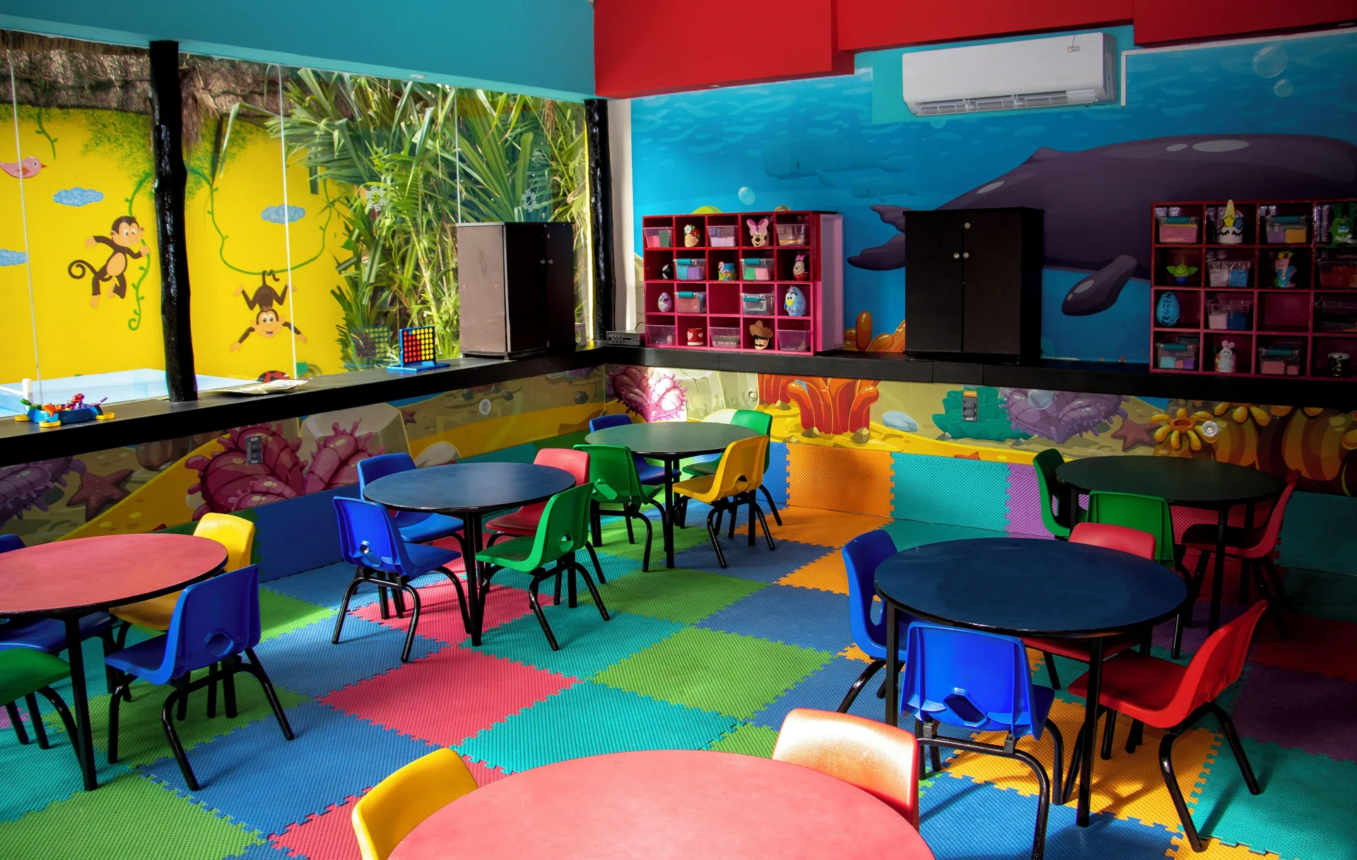 Children’s activity room with small tables and ocean murals at Grand Oasis Cancun.
