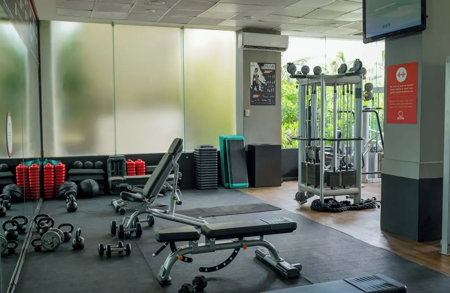 Fitness room with benches, weights, and cable machine at Grand Oasis Cancun.