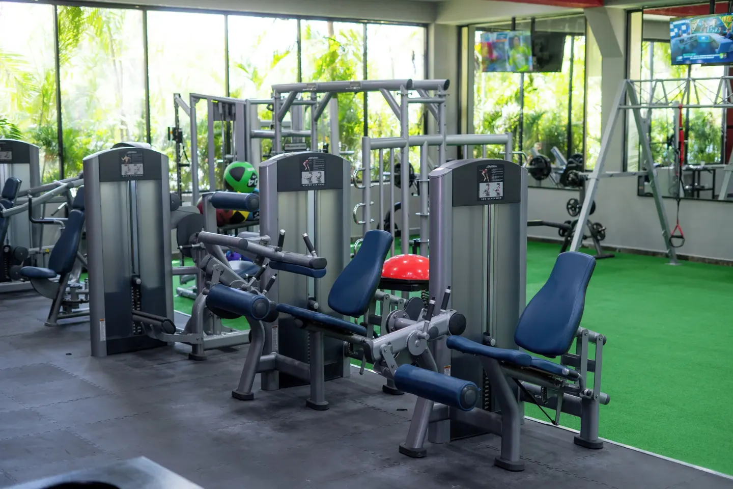 Fitness room with weight machines, turf area, and mirrors at Grand Oasis Cancun.