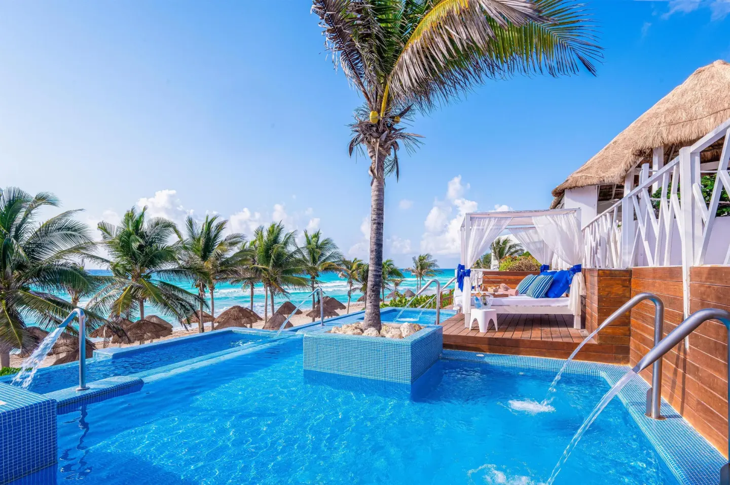 Oceanfront pool terrace with cabanas and water jets at Grand Oasis Cancun.