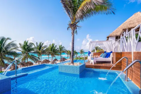 Oceanfront pool terrace with cabanas and water jets at Grand Oasis Cancun.