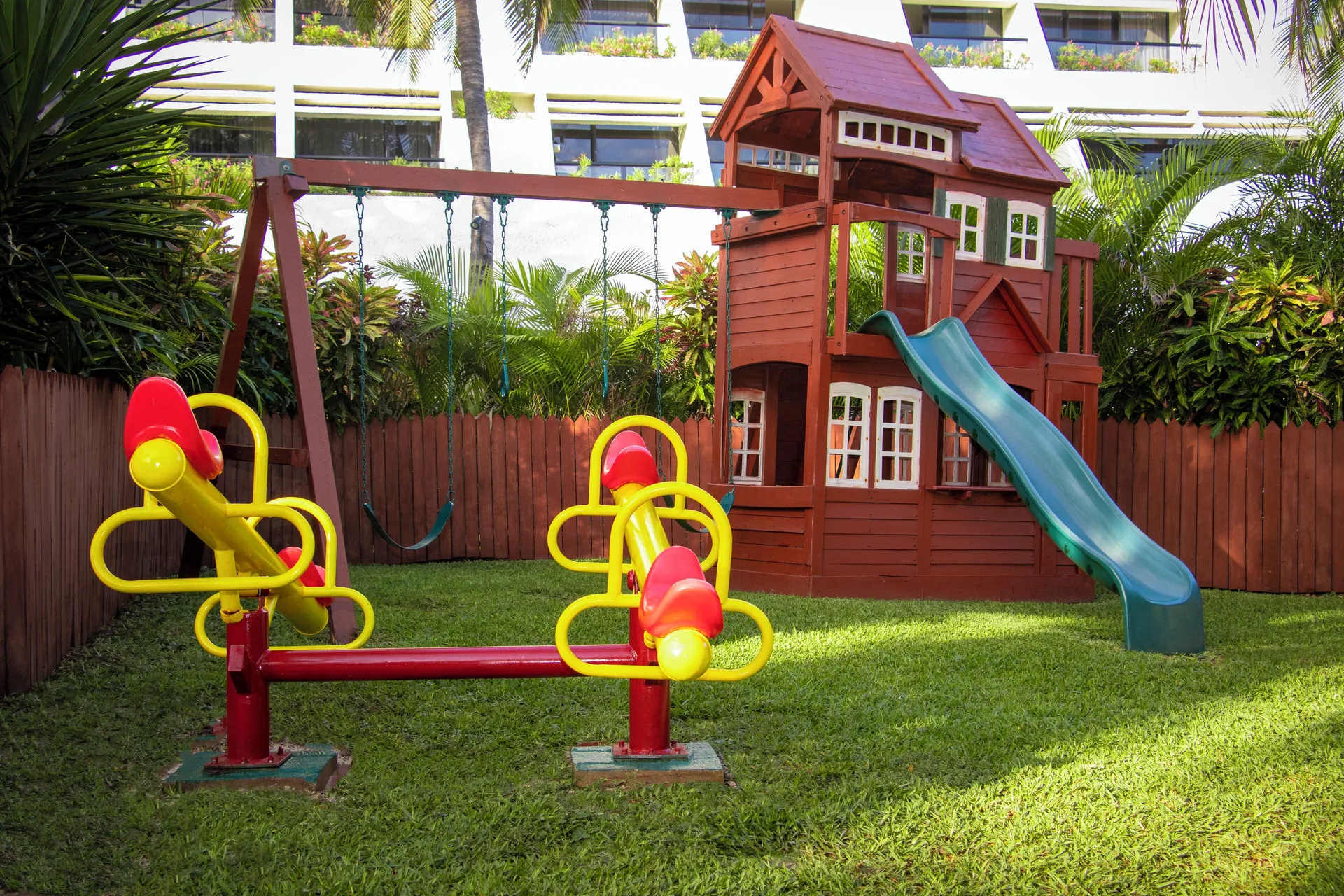Outdoor playground with swings, slides, and seesaws at Grand Oasis Cancun.