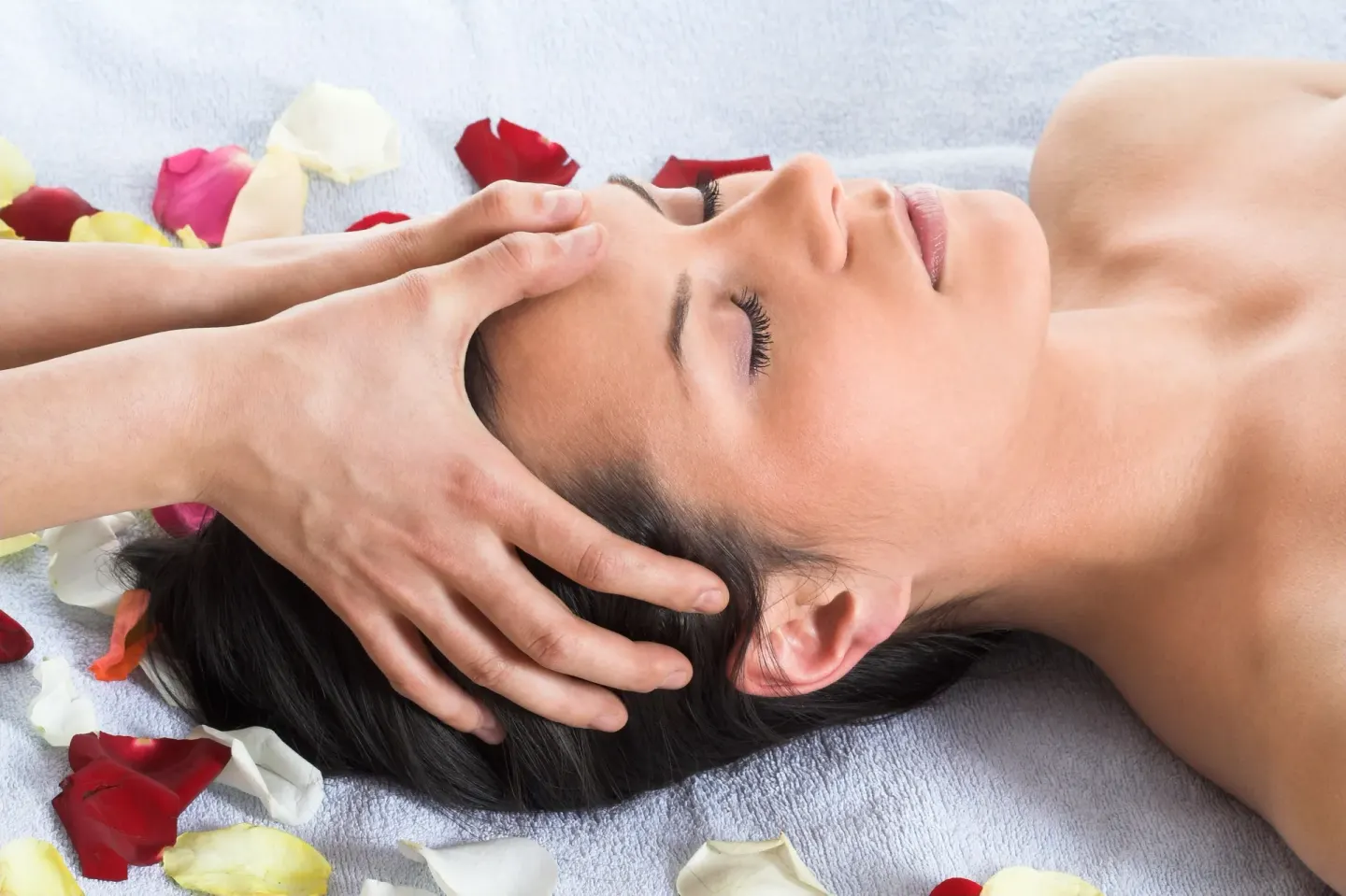 Close-up of a relaxing head massage with rose petals at Grand Oasis Cancun.
