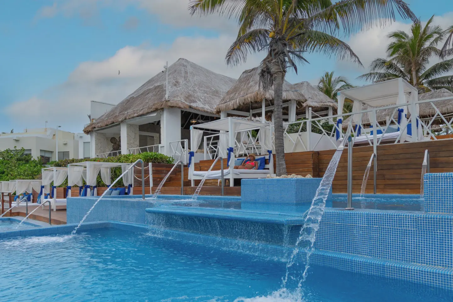 Tiered pool with water jets, cabanas and thatched roofs at Grand Oasis Cancun.