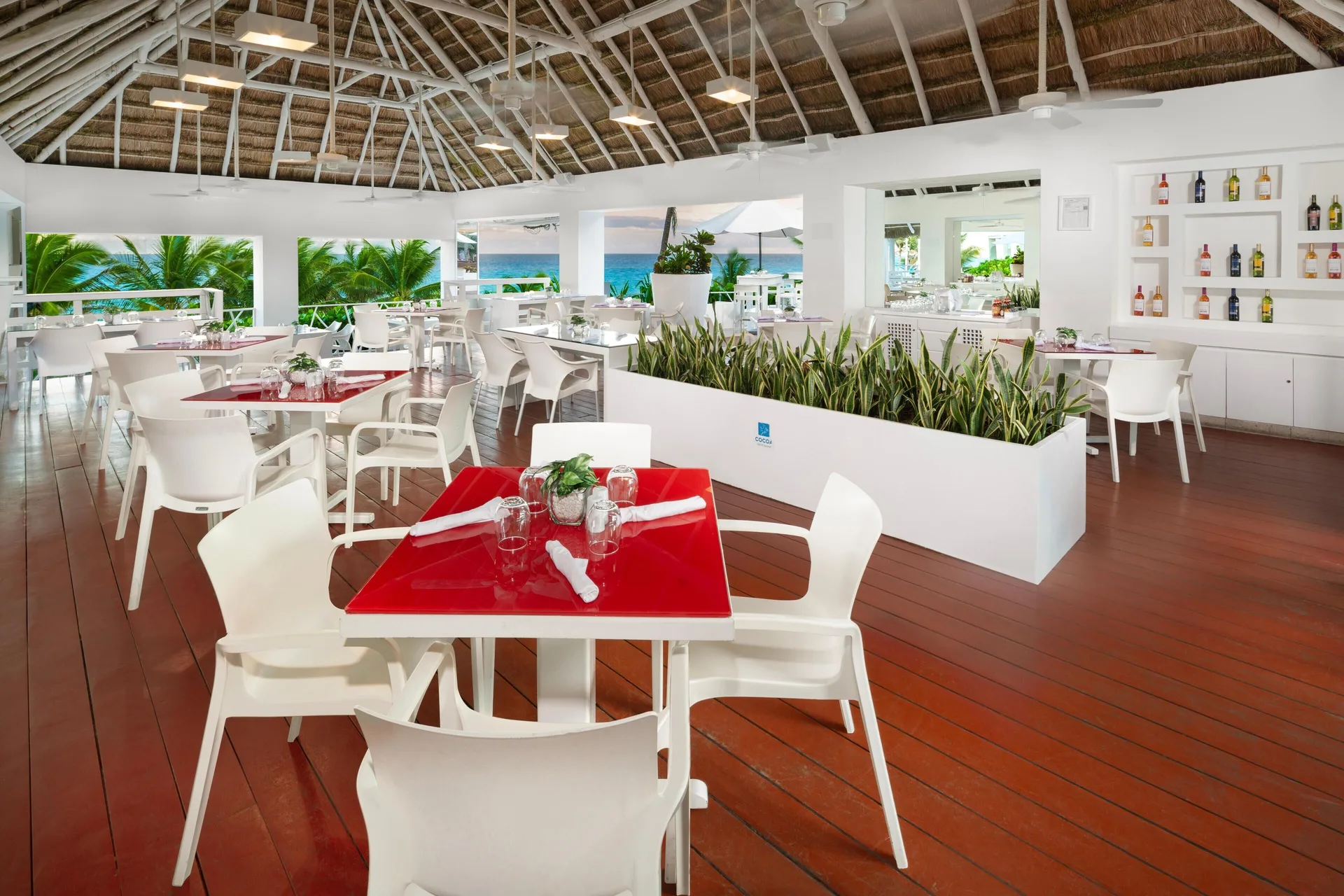 Bright ocean-view dining terrace with white chairs at Grand Oasis Cancun.