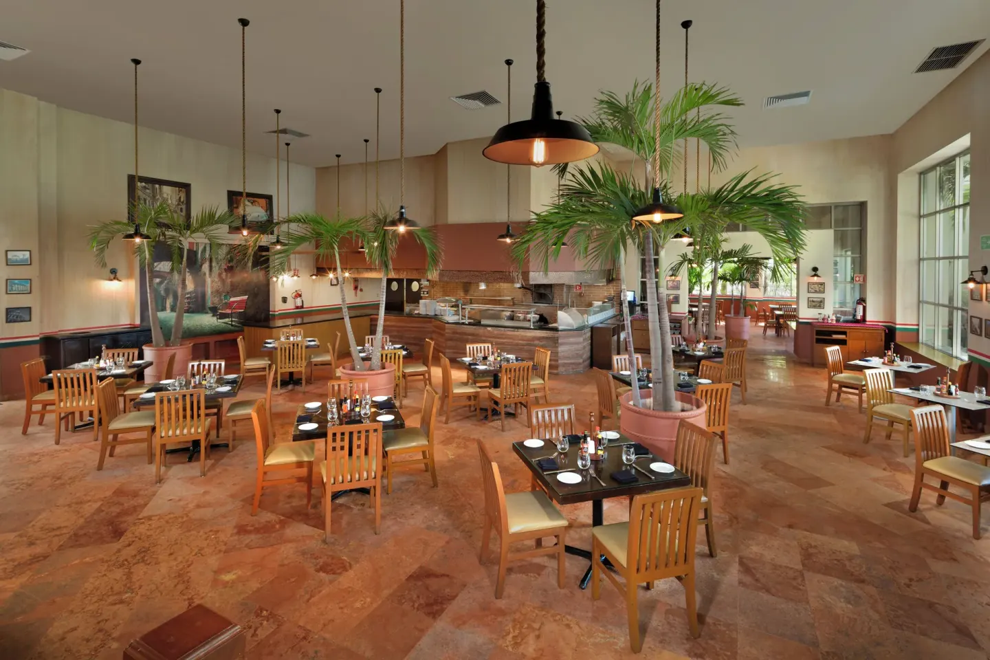 Large dining room with potted palms and buffet counters at Grand Oasis Cancun.