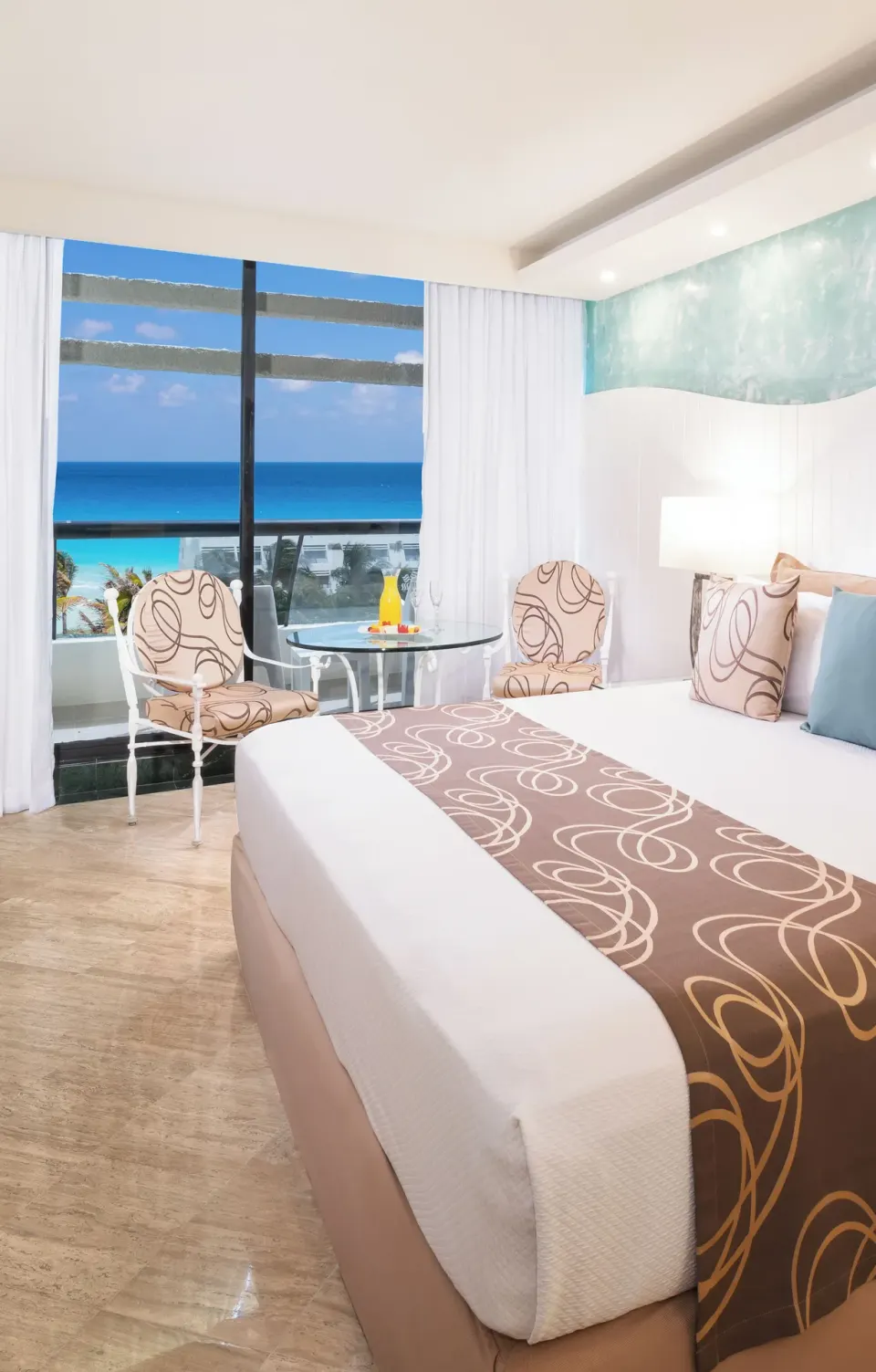 Grand Ocean View king bed room with seating by the window at Grand Oasis Cancun.