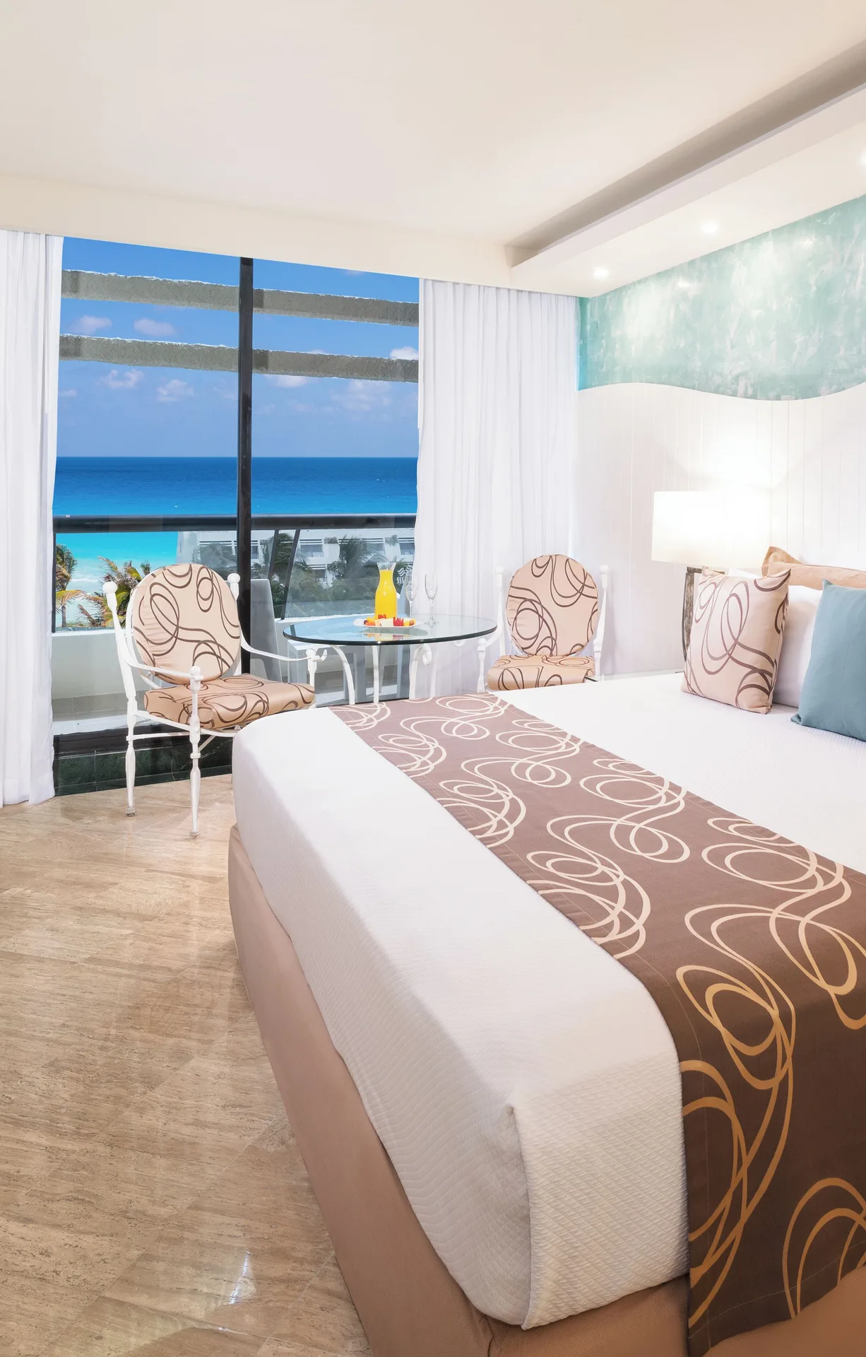 Grand Ocean View king bed room with seating by the window at Grand Oasis Cancun.