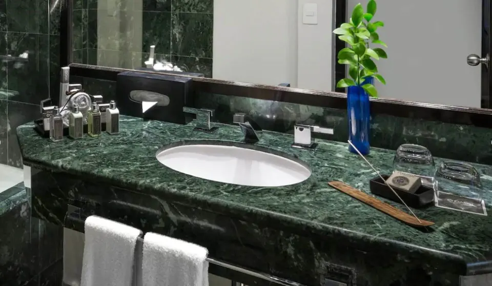 Grand Standard bathroom vanity at Grand Oasis Cancun with green stone counter and amenities.