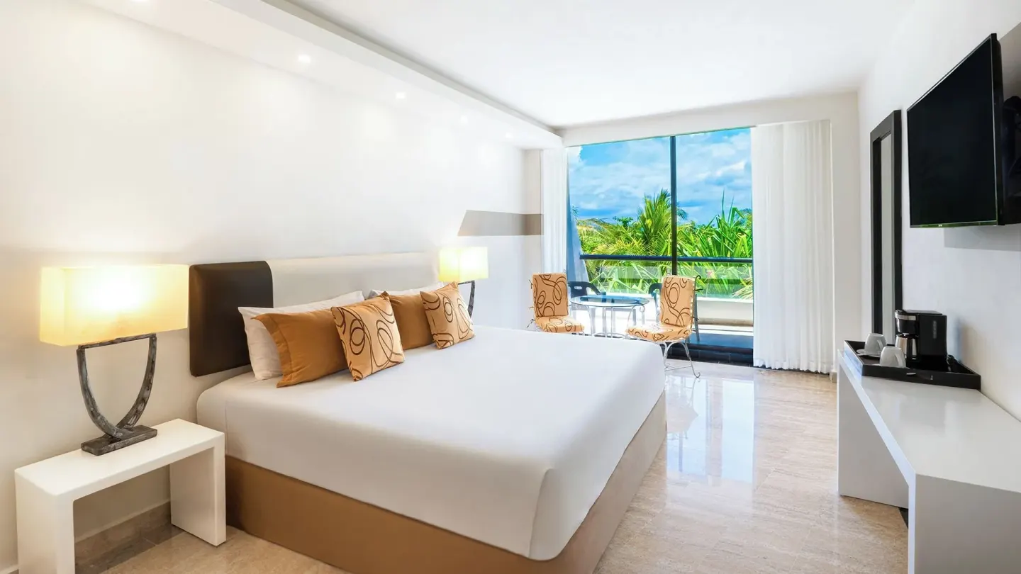Grand Standard king room with balcony seating and palm view at Grand Oasis Cancun.