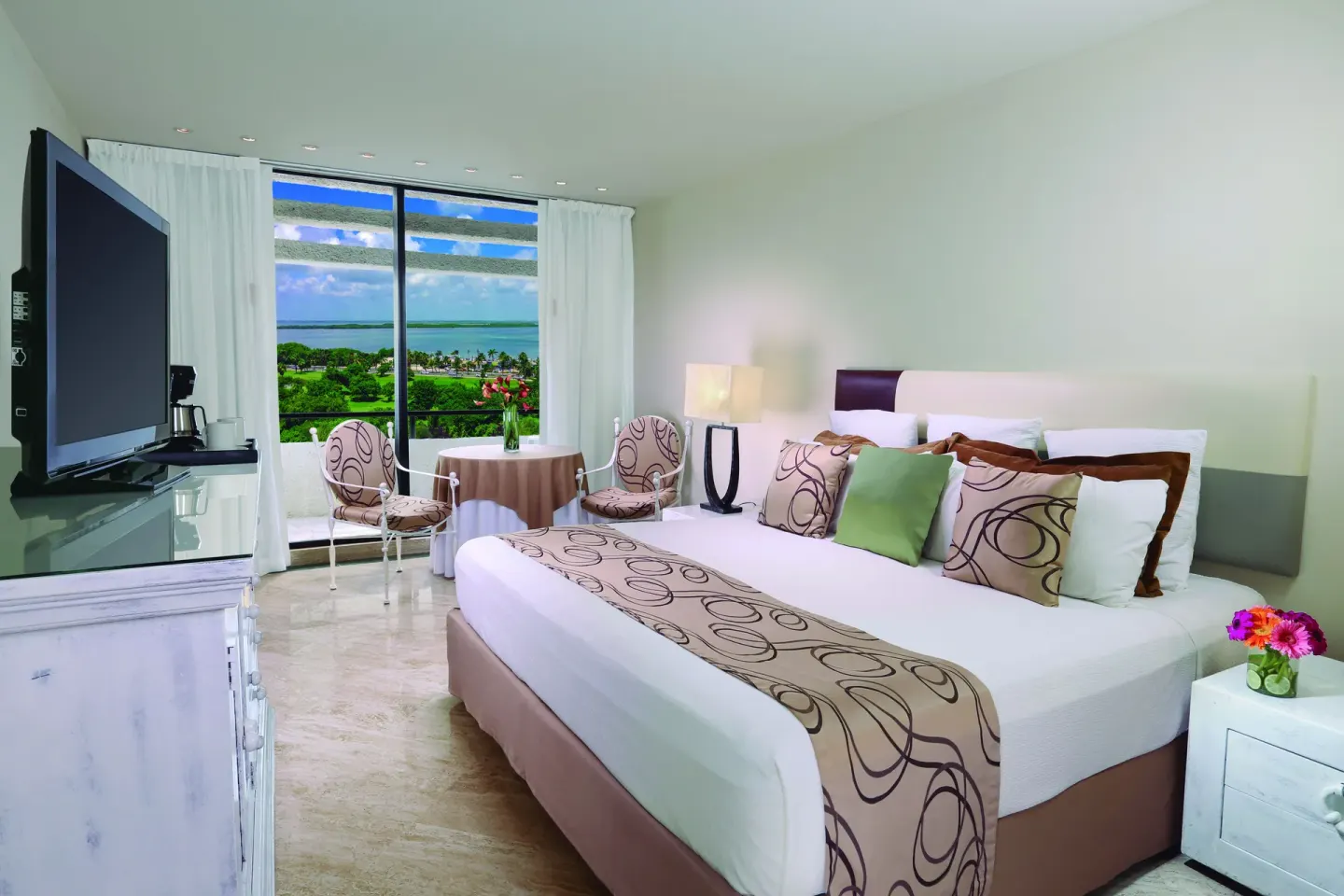 Grand Standard king room at Grand Oasis Cancun with seating area, TV and lagoon view.