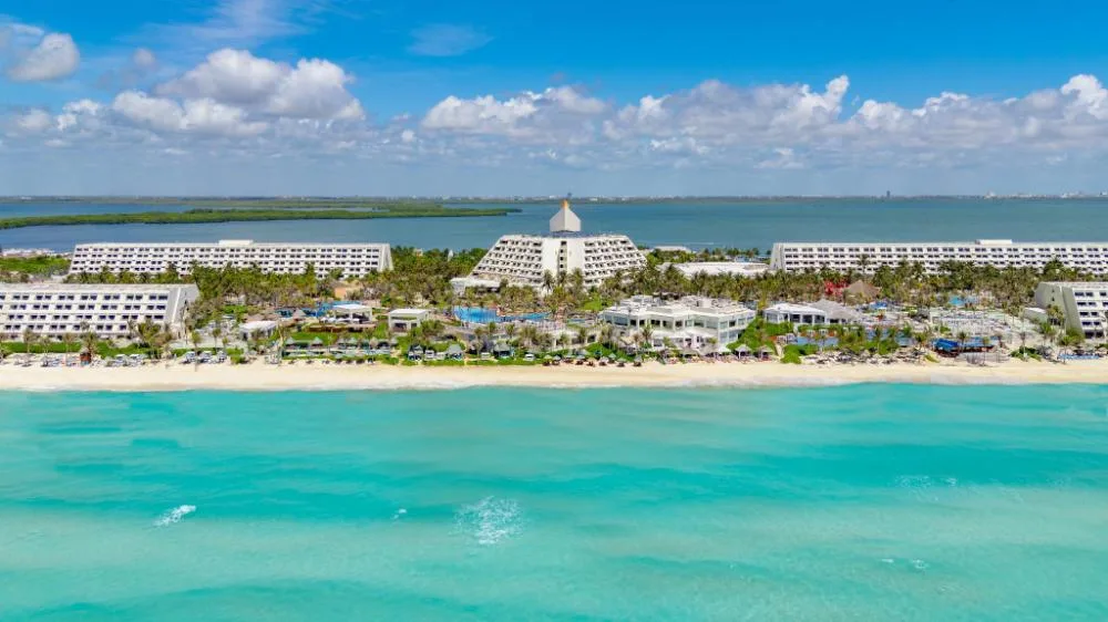 Aerial view of Grand Oasis Cancun between the turquoise sea and lagoon.