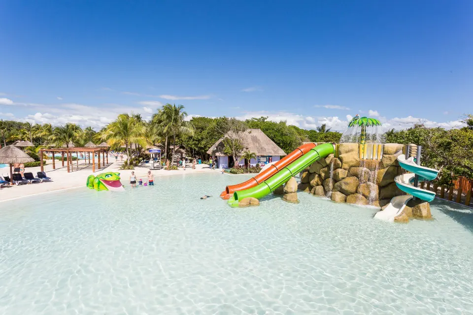 Shallow kids' splash area with colorful water slides at Grand Palladium Colonial Resort & Spa
